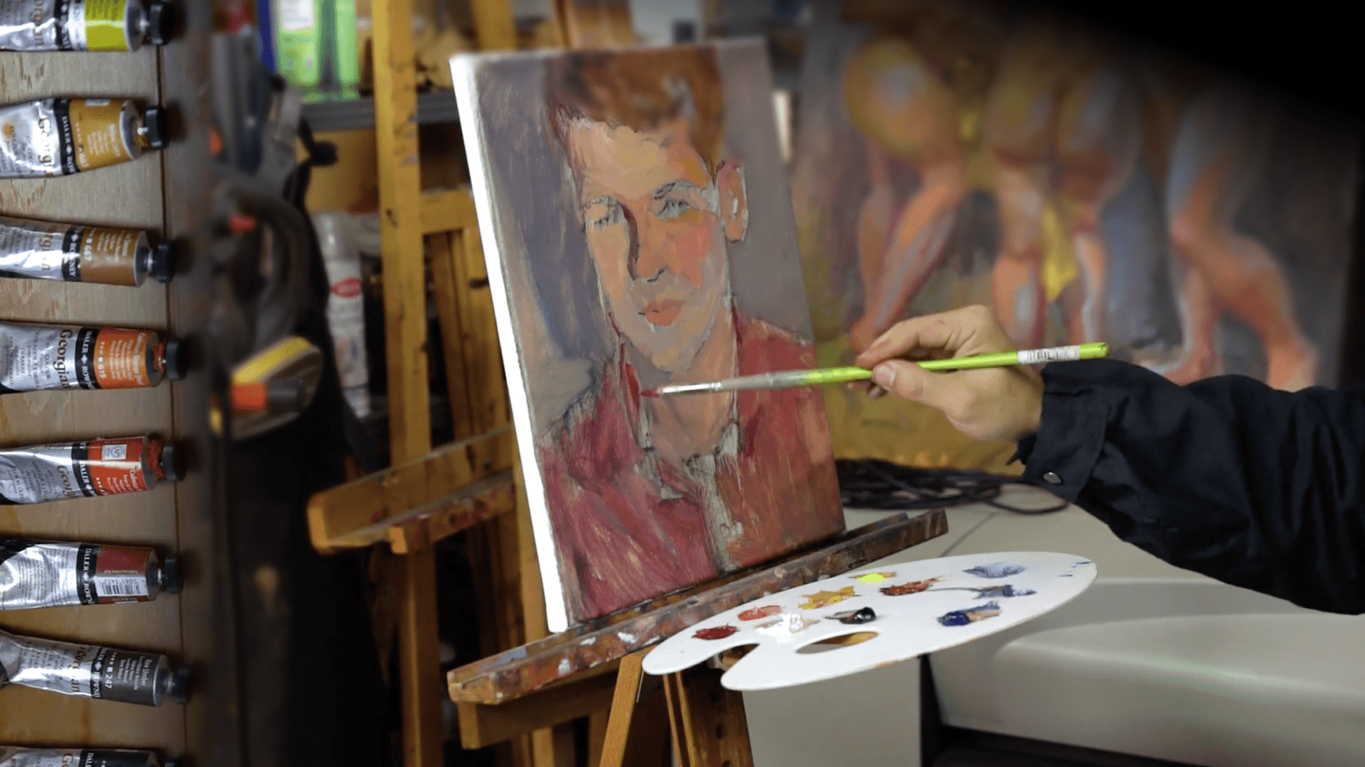 A shot of Alex painting a male portrait